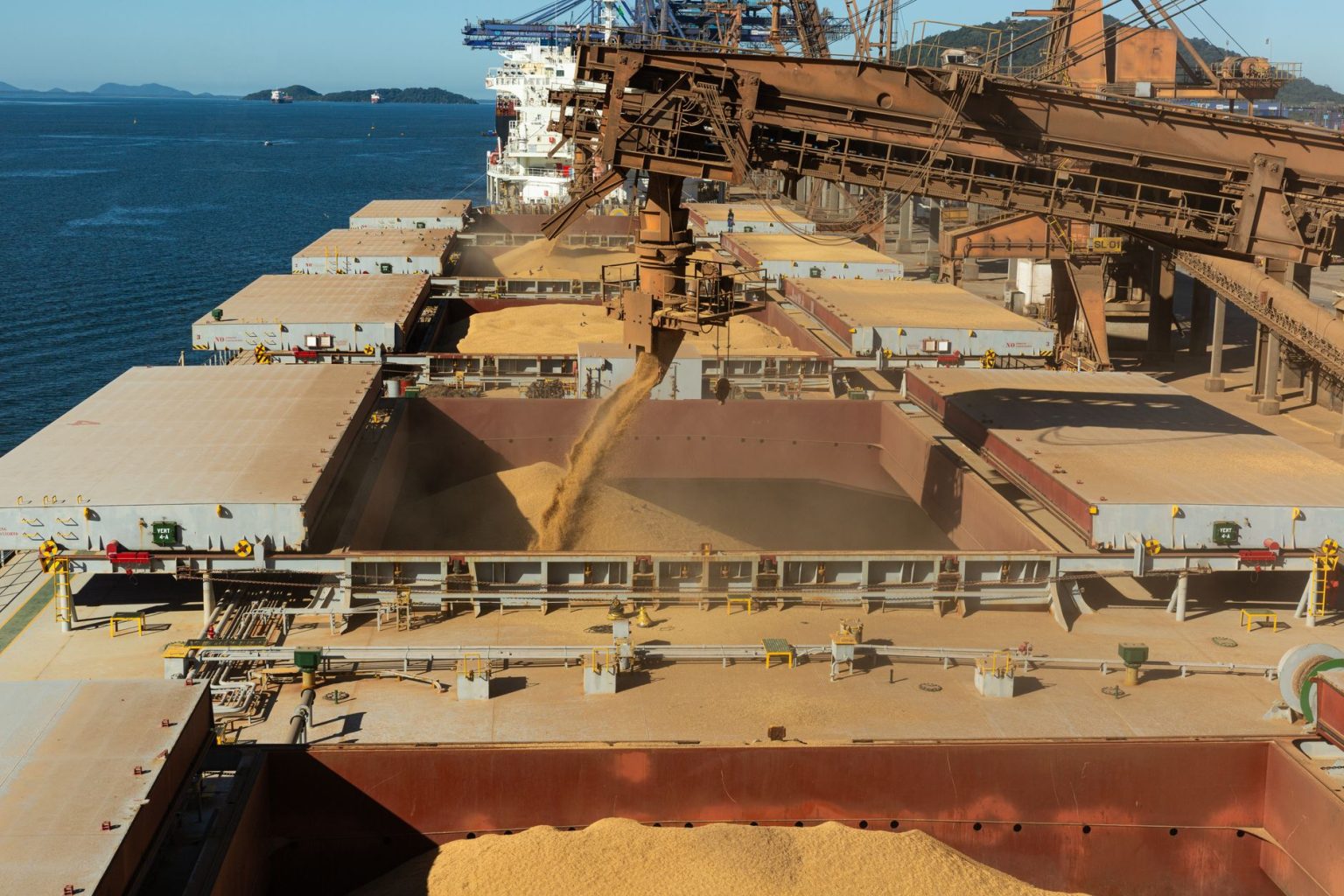 Navio de carga sendo carregado com grãos em um porto industrial