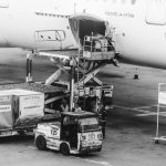 Operação de carregamento de carga em uma aeronave estacionada no aeroporto.